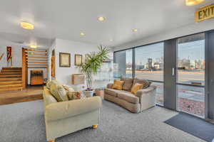 Carpeted living room featuring wood walls