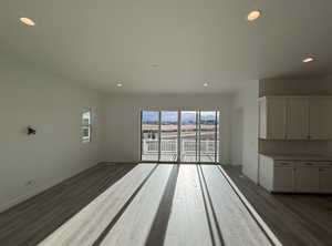 Unfurnished living room with dark wood-type flooring