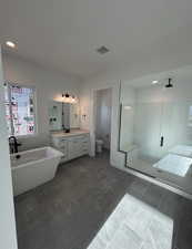 Full bathroom with tile patterned floors, vanity, plus walk in shower, and toilet