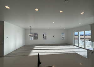 Unfurnished living room with an inviting chandelier