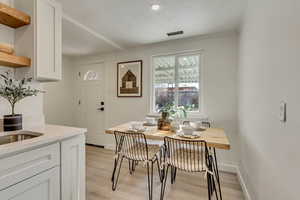 Dining room featuring a textured ceiling and light hardwood / wood-style flooring