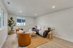 Living room with crown molding and light hardwood / wood-style flooring