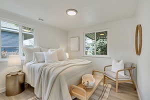 Bedroom with light hardwood / wood-style flooring and ornamental molding