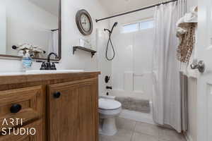 Full bathroom featuring toilet, tile patterned floors, vanity, and shower / tub combo with curtain