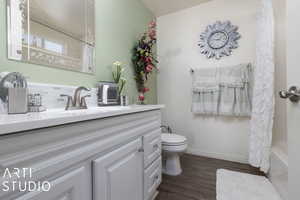 Full bathroom with vanity, shower / bath combination with curtain, toilet, tasteful backsplash, and wood-type flooring