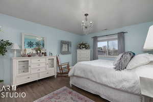 Bedroom featuring dark hardwood / wood-style flooring and an inviting chandelier