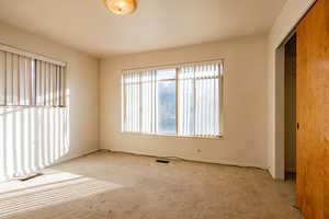 Unfurnished bedroom with light carpet and a closet