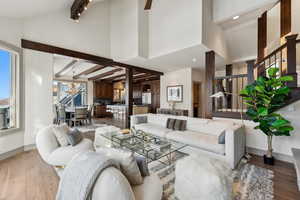 Living room featuring hardwood / wood-style floors, high vaulted ceiling, and beam ceiling