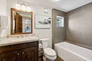 Full bathroom featuring tile patterned floors, vanity, toilet, and tiled shower / bath combo