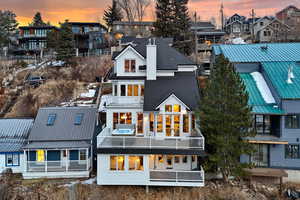 Back house at dusk with a balcony