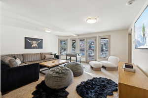 Carpeted living room with beam ceiling