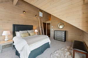 Carpeted bedroom featuring wood walls, wood ceiling, and vaulted ceiling