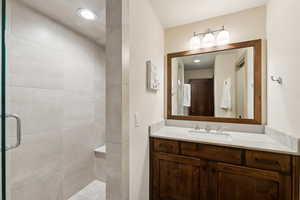 Bathroom featuring vanity and a shower with door