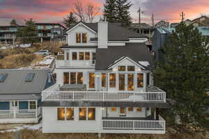 Back house at dusk with a balcony and french doors