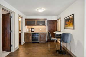 Interior space with backsplash, dark hardwood / wood-style floors, and beverage cooler