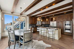 Kitchen with appliances with stainless steel finishes, backsplash, and hardwood / wood-style floors