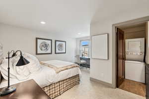 Carpeted bedroom featuring stacked washer and clothes dryer