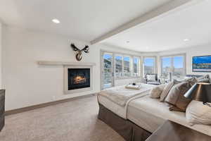 Bedroom with carpet, beam ceiling, and access to outside