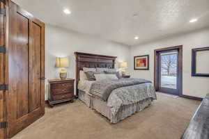 Bedroom with access to outside, light colored carpet, and a textured ceiling