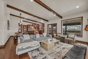 Living room featuring dark hardwood / wood-style floors and lofted ceiling with beams