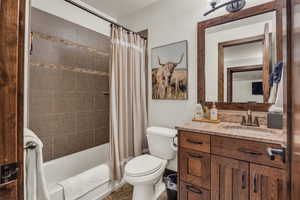 Full bathroom with shower / tub combo with curtain, vanity, and toilet