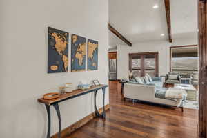 Living room featuring beamed ceiling and dark wood-type flooring