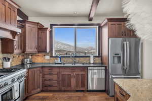 Kitchen featuring dark hardwood / wood-style flooring, dark stone counters, stainless steel appliances, sink, and a mountain view