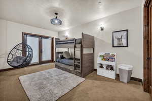 Carpeted bedroom featuring a textured ceiling