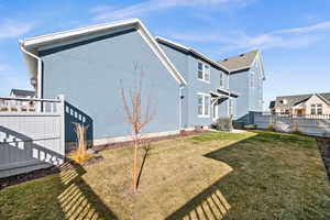 Rear view of property with central AC and a lawn