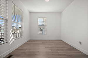 Unfurnished room featuring plenty of natural light and wood-type flooring