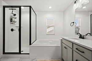 Bathroom featuring plus walk in shower and vanity