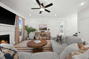 Living room with ceiling fan and a brick fireplace