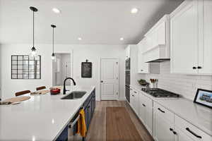 Kitchen with dark hardwood / wood-style floors, white cabinetry, stainless steel gas cooktop, and sink