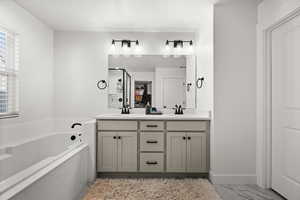 Bathroom with tiled tub and vanity