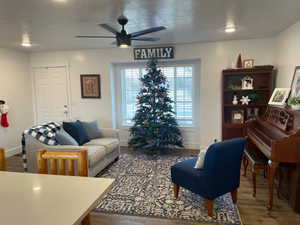 Living room featuring LVP flooring, a textured ceiling, and ceiling fan