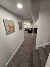 Corridor featuring carpet floors and a textured ceiling