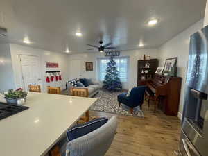 Living room with a textured ceiling, LVP floors, and ceiling fan