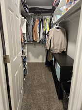 Walk in closet featuring dark carpet