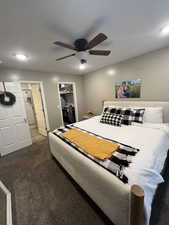 Bedroom featuring a closet, dark carpet, and ceiling fan