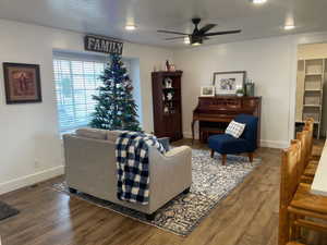 Living room with LVP floors, a textured ceiling, and ceiling fan