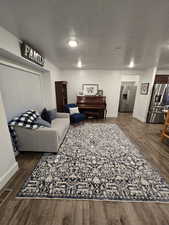 Living room with dark hardwood / wood-style floors and a textured ceiling