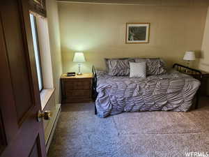 Carpeted bedroom featuring a baseboard radiator