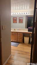 Bathroom with hardwood / wood-style flooring, vanity, and a textured ceiling