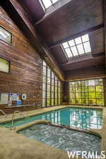 View of swimming pool featuring a skylight