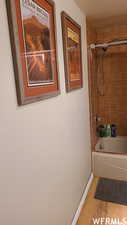 Bathroom featuring hardwood / wood-style floors and tiled shower / bath combo