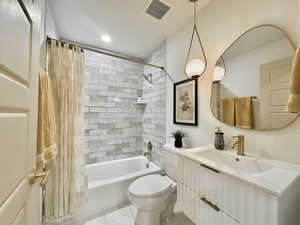 Full bathroom with tile patterned flooring, shower / bath combo, vanity, and toilet