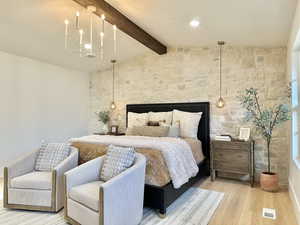 Bedroom featuring vaulted ceiling with beams, hardwood / wood-style flooring, and an inviting chandelier