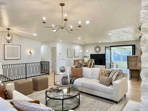 Living room featuring a chandelier, a textured ceiling, and light hardwood / wood-style floors