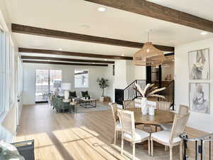 Dining area with beam ceiling and light hardwood / wood-style floors