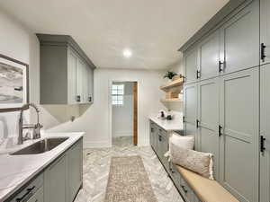 Clothes washing area featuring cabinets, hookup for a washing machine, and sink